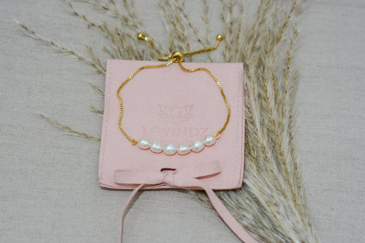 Pulsera ajustable, hecha en perla de río y chapa de oro de
18 kilates